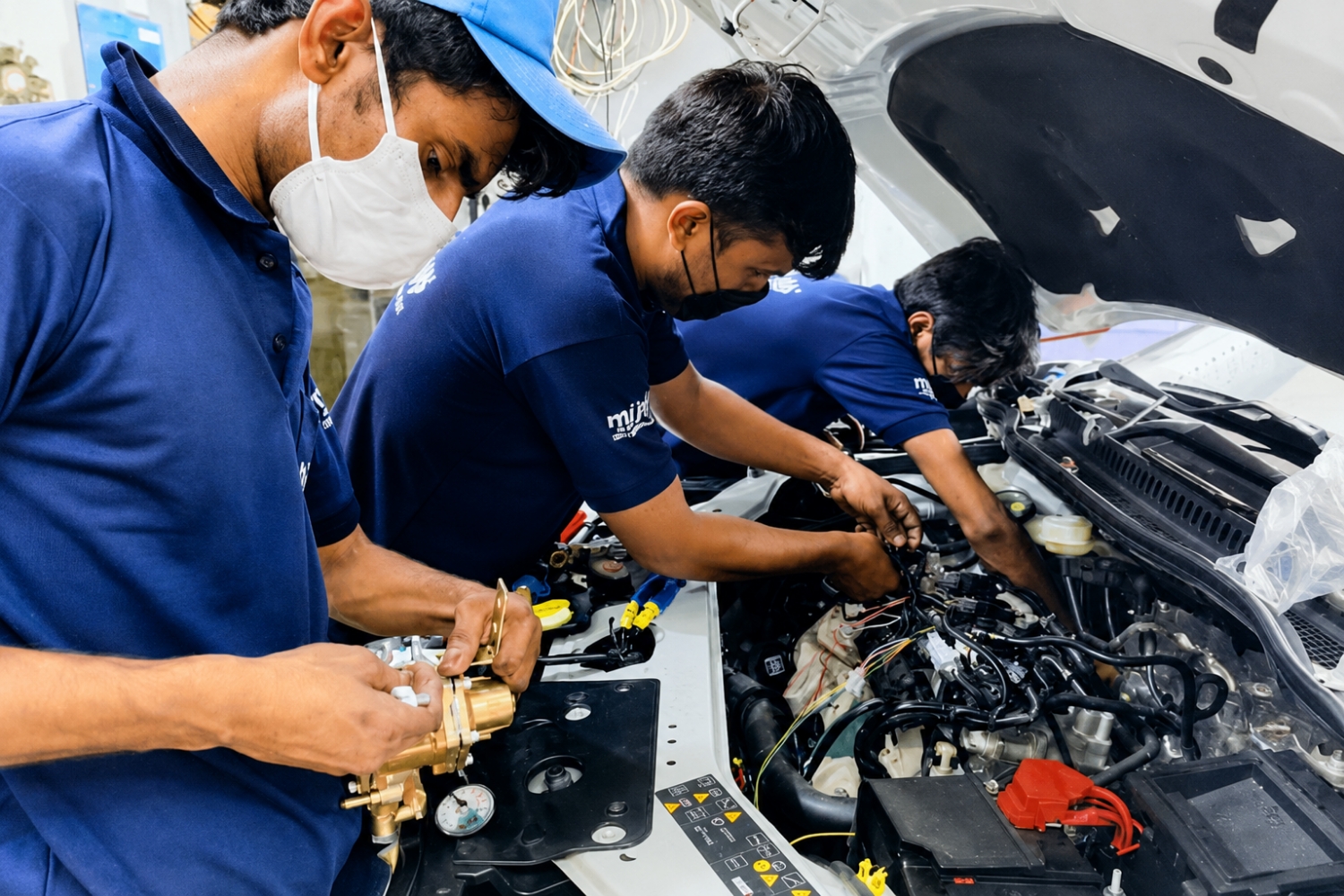 Certified LetsGO CNG technician installing a kit in the engine bay